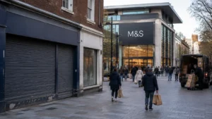 Closed high-street shop beside a busy modern M&S store showing changes in UK retail