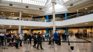 Shoppers queuing outside Primark inside a busy shopping centre